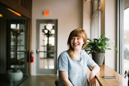 Woman sitting in front of a wooden table