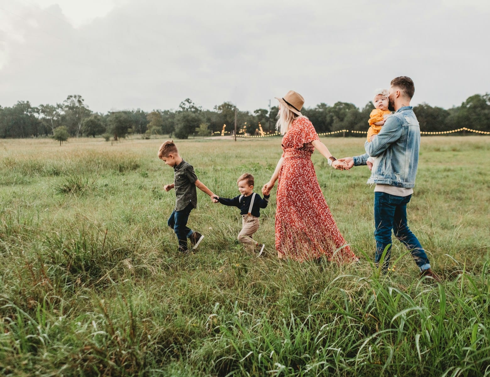 Family walking through a field holding hands