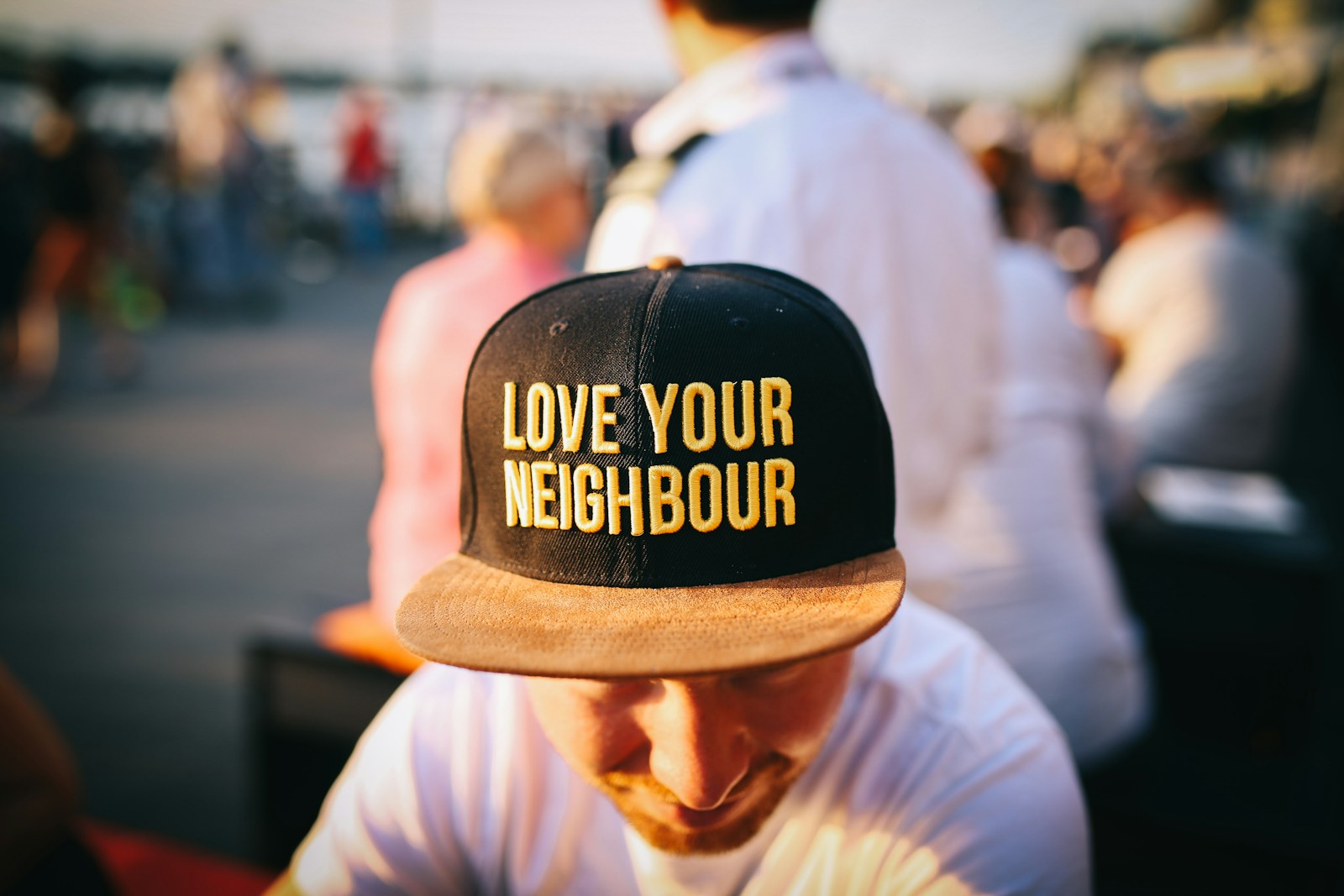 man wearing black cap with love your neighbor print during daytime
